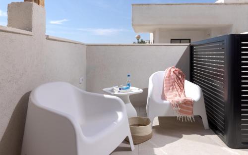 a small balcony with two chairs and a table at אורה דירות אירוח -נץ 9- דירות נופש איכותיות לנופש שקט ואקסלוסיבי in Eilat