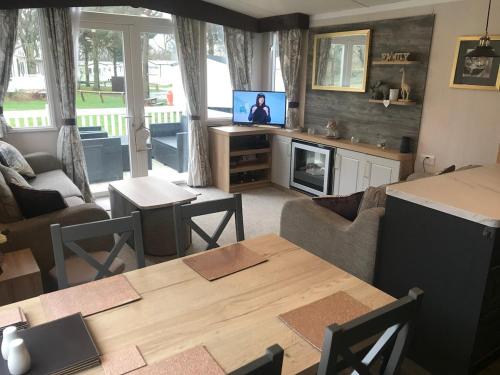 モーペスにあるLuxury Caravan Cresswellのテーブルとテレビのあるリビングルーム