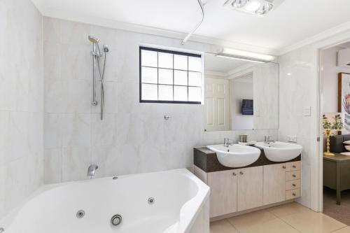 La salle de bains blanche est pourvue de 2 lavabos et d'une baignoire. dans l'établissement City Haven, 2Bed, 2Bath, Parking, Balcony, à Brisbane
