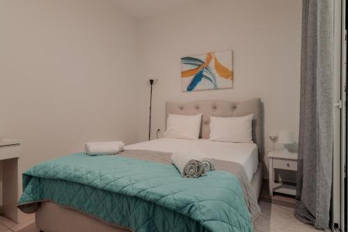 a bedroom with a bed with a green blanket at Spyridoula's apartment in Nafplio