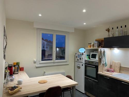 une cuisine avec une table et une cuisine avec une fenêtre dans l'établissement Charming downtown Riom apartment, à Riom