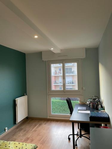 une chambre vide avec un bureau et une fenêtre dans l'établissement Charming downtown Riom apartment, à Riom