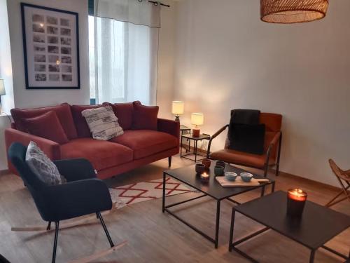 a living room with a red couch and two chairs at La Bergerie à Palleau, Les Blés Dorés et Les Graines de Lin à Corgengoux, proches de Beaune et de ses villages viticoles in Palleau