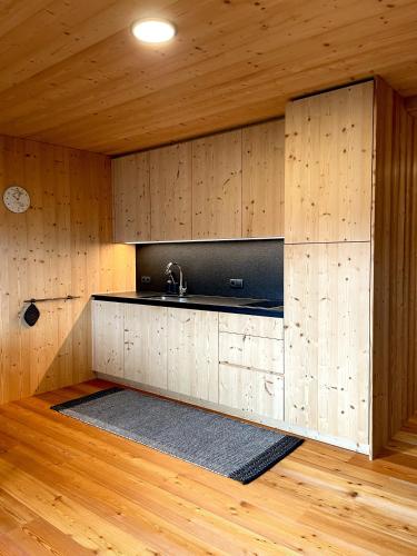 a kitchen with a sink and wooden walls and wood floors at Schallerhof Sterzing - Deine Auszeit mit Ausblick in unseren Ferienwohnungen auf dem Bergbauernhof in Südtirol in Vipiteno
