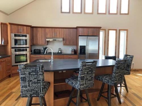 une cuisine avec un grand îlot avec des chaises de bar dans l'établissement Cottage apartments at Lake Huron, à Midland