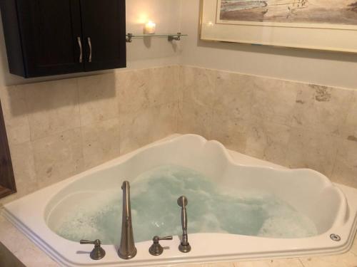 La salle de bains est pourvue d'une baignoire remplie d'eau. dans l'établissement Cottage apartments at Lake Huron, à Midland