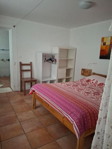 a bedroom with a bed and a chair at NORDIQUES DE LA WELCHE in Orbey