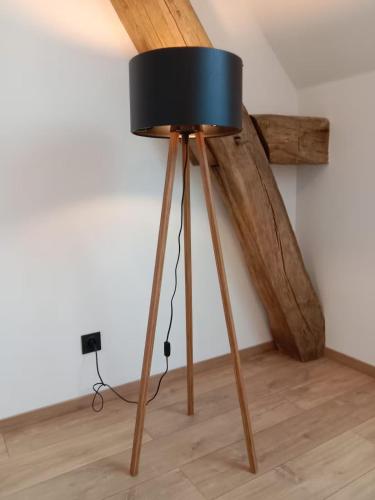 a black lamp on a wooden tripod in a room at La Bergerie à Palleau, Les Blés Dorés et Les Graines de Lin à Corgengoux, proches de Beaune et de ses villages viticoles in Palleau