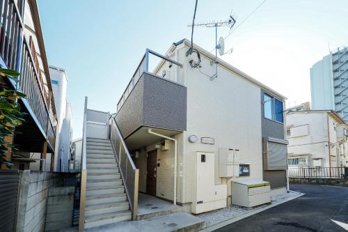 a building with a staircase leading to a garage at Zenith Garden TOGOSHI in Tokyo