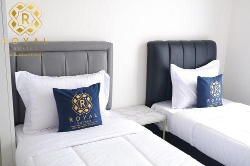 a bedroom with two beds with blue and white pillows at Royal Suites 2BR 28RV - Citra Plaza Nagoya Apartment in Jodoh