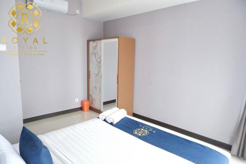 a bedroom with a bed with blue and white sheets at Royal Suites 2BR 28RV - Citra Plaza Nagoya Apartment in Jodoh