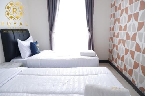a room with two beds and a window at Royal Suites 2BR 28RV - Citra Plaza Nagoya Apartment in Jodoh