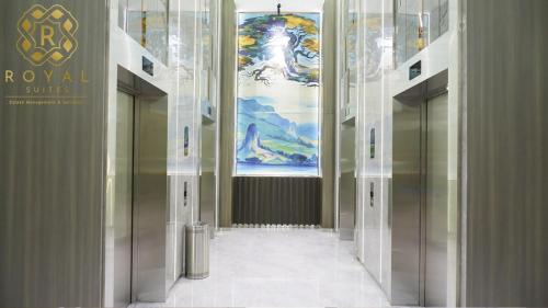 a hallway with elevators in a building with a painting at Royal Suites 2BR 28RV - Citra Plaza Nagoya Apartment in Jodoh