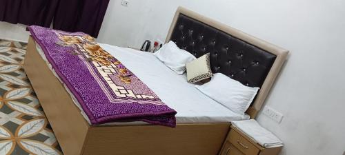 a bed with a purple blanket on top of it at Amit home stay in Jhūsi