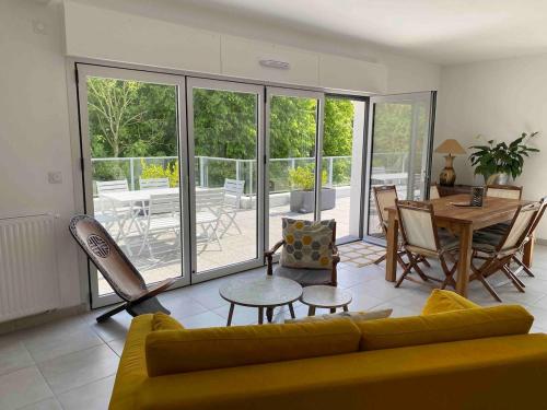 un salon avec un canapé jaune et une table dans l'établissement Appartement spacieux et lumineux St Malo Paramé, à Saint-Malo