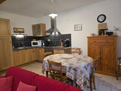 une cuisine avec une table recouverte d'une nappe dans l'établissement Le Batteux chez bidou, à Quesnoy-le-Montant