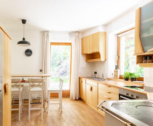 a kitchen with wooden cabinets and a table and chairs at Large apartment with panoramic view in Meluno