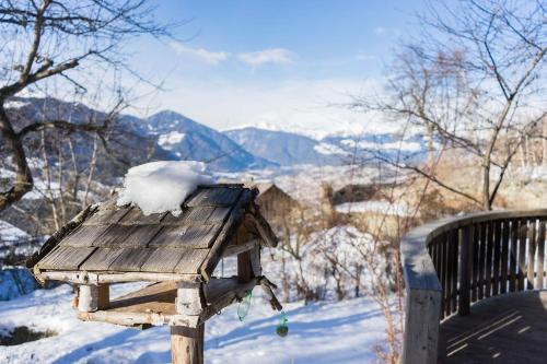 a wooden bird house with snow on top of it at Large apartment with panoramic view in Meluno