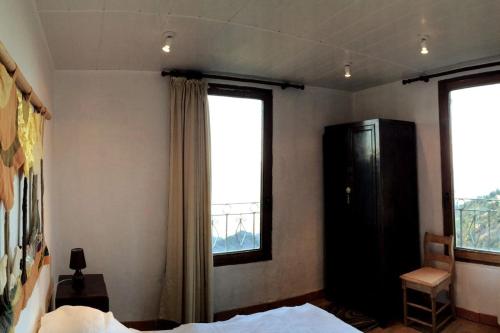 une chambre avec un lit et une grande fenêtre dans l'établissement House between the sea and the mountain, à San-Giovanni-di-Moriani