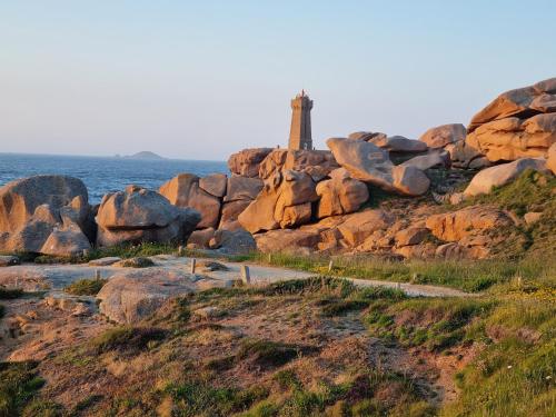 un phare sur les rochers près de l'océan dans l'établissement Gîtes Aux Quatre vents, à Lannion