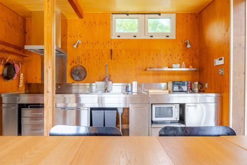 a kitchen with a sink and two chairs in it at Sea and Gallery house館山 in Tateyama
