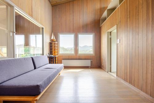 a living room with a couch and some windows at Sea and Gallery house館山 in Tateyama