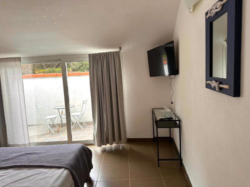a bedroom with a bed and a television and a balcony at Marina Vernazza Design Rooms in Vernazza