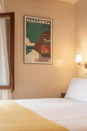 a bedroom with a bed and a picture of a train at SólleRooms in Sóller