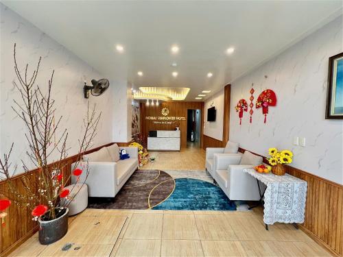 a living room with white couches and a blue rug at Noi Bai Sunflower Hotel in Noi Bai
