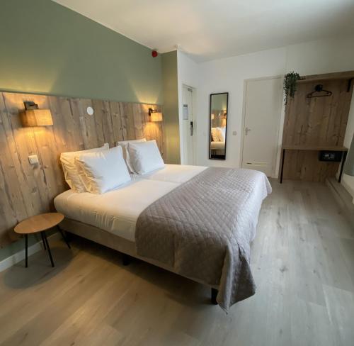 a bedroom with a large bed with white sheets at Hotel Emilia in Kaatsheuvel