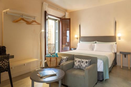 a hotel room with a bed and a chair at SólleRooms in Sóller