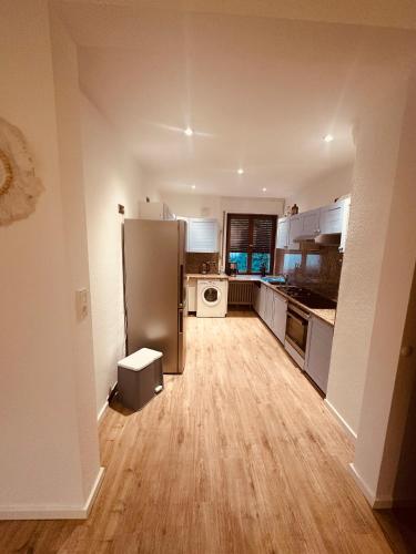 a kitchen with a stainless steel refrigerator and wooden floors at Ferienwohnung 27 in Holzminden