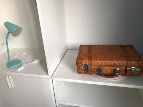 a suitcase sitting on a shelf next to a lamp at Apartment in Gelb, mit Balkon, Kamin, 50 Schritte zu Radweg, ideal for Long Stay, 4 Singles in Single Rooms in Mainstockheim