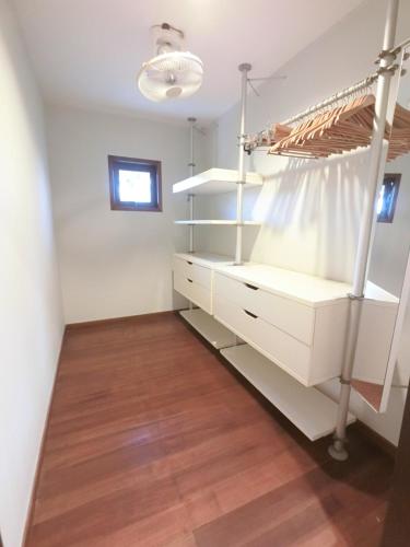 a dressing room with white cabinets and a wooden floor at Tropical Pool Villa Langkawi in Pantai Cenang