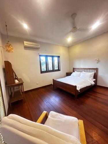 a bedroom with two beds and a wooden floor at Tropical Pool Villa Langkawi in Pantai Cenang