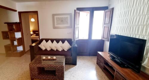 ein Wohnzimmer mit Sofa und Fernseher in der Unterkunft Sa Tanca den Marines ETV 1272 E in Sant Carles de Peralta
