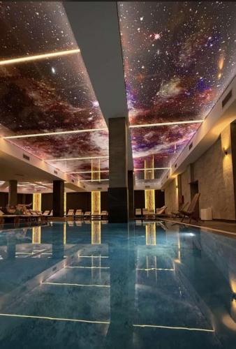 a swimming pool with a starry sky mural on the ceiling at Fashion Residence Hill in Kopaonik