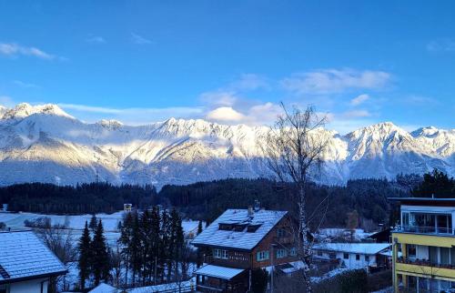 a view of a snowy mountain range with houses at Hotel-Restaurant Batzenhäusl in Innsbruck