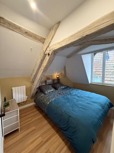 - une chambre mansardée avec un grand lit bleu dans l'établissement Les Combles de Colbert- hyper center, à Troyes