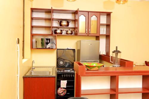 una piccola cucina con piano cottura e bancone di Kirungi Vacation Homes a Fort Portal