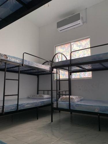 a room with three bunk beds and a window at Awienna House in Kota Kinabalu