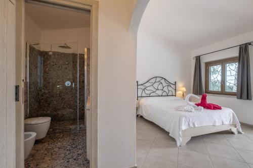 a bedroom with a bed and a bathroom with a shower at Piscina Privata- Luxury Villa 100m dalla Spiaggia in Palau