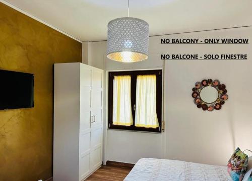 a room with a bed and a television and a window at BluMare ArtHouse in Salerno