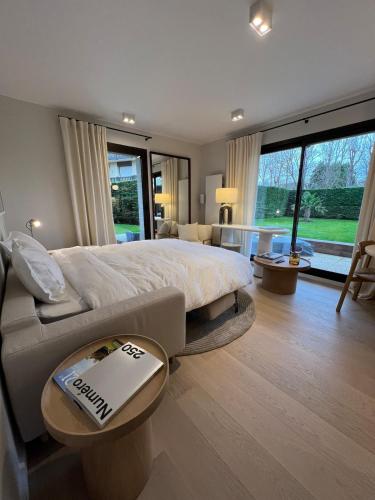 une chambre avec un grand lit et un canapé dans l'établissement La Suite Jardin Premium - 2 personnes - Plage Deauville, à Deauville