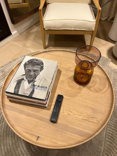 - un livre et une télécommande sur une table basse dans l'établissement La Suite Jardin Premium - 2 personnes - Plage Deauville, à Deauville