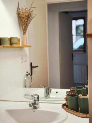 une salle de bain avec un lavabo et un miroir dans l'établissement Studio vue montagnes RDC piscine, à Cauterets