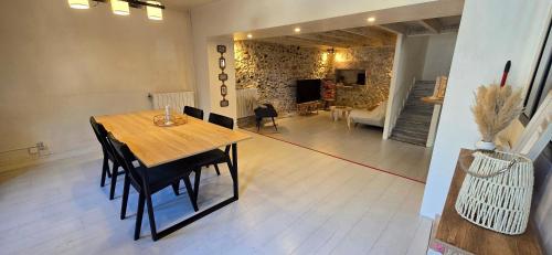 a dining room with a wooden table and chairs at La charmante in Puyoô
