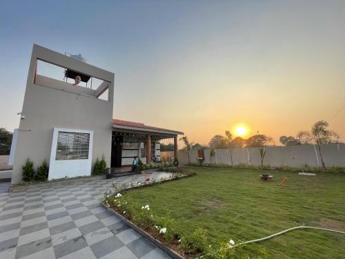 a house with the sunset in the back yard at The Bourbon Estate in Mahirāvani