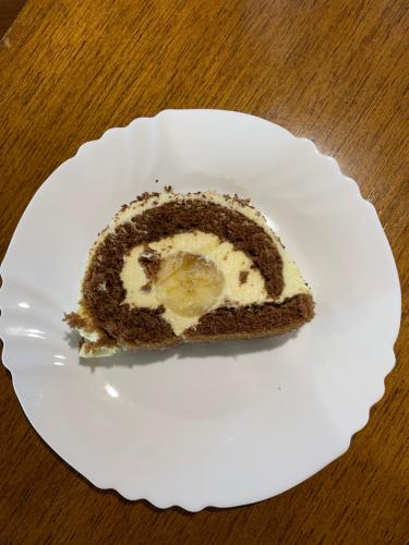 a piece of cake on a white plate on a table at Bungalovi Blagojević in Morović