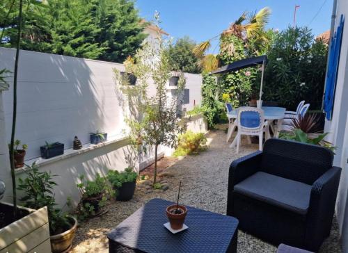 a small patio with a chair and a table at La charmante in Puyoô